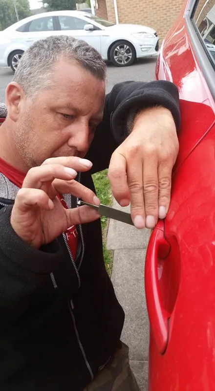 Locksmith using a LISHI tool to open a locked car damage-free