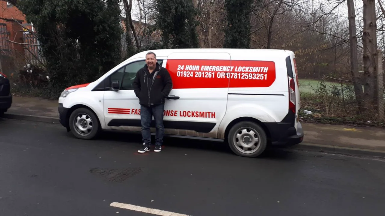 Fast Response Locksmiths van with 24-hour emergency locksmith signage, the locksmith standing in front of it